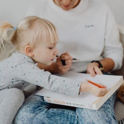 Girl and her mom practicing pre primer sight words together with worksheet