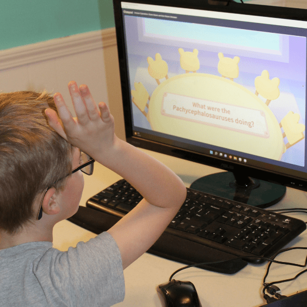 child raising hand to ask a question while participating in Online Homeschool Electives with Allschool