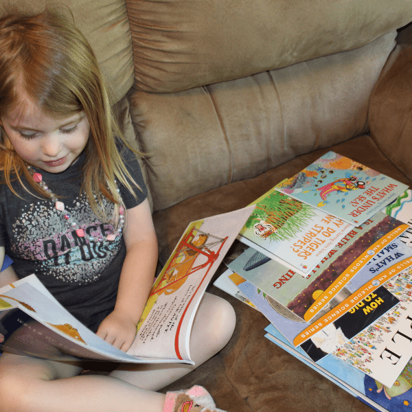 girl reading books for preschool with Sonlight