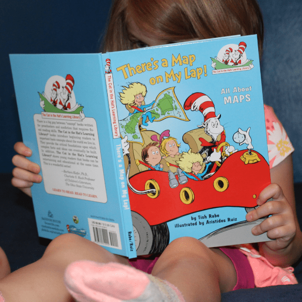 girl reading a book about maps