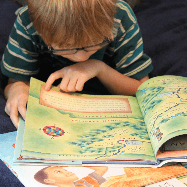 child reading from his Charlotte Mason Homeschool Geography Curriculum from Beautiful Feet Books