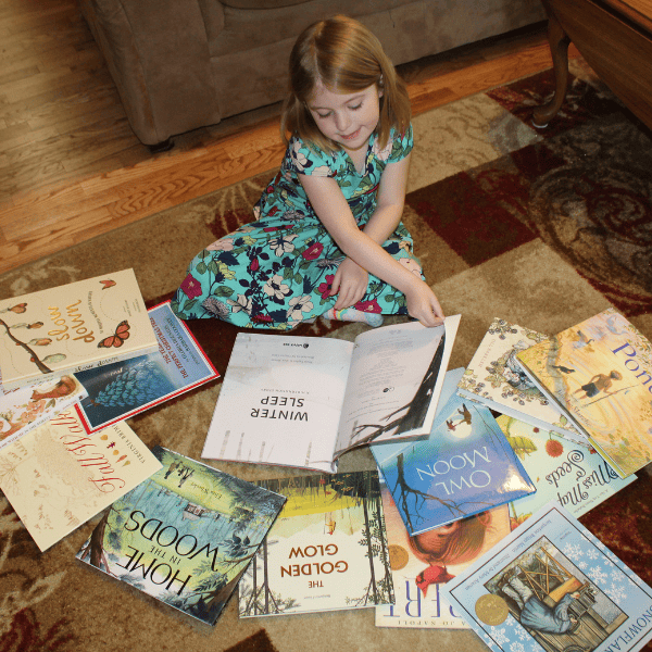 child reading books from Seasons Afield homeschool nature study curriculum